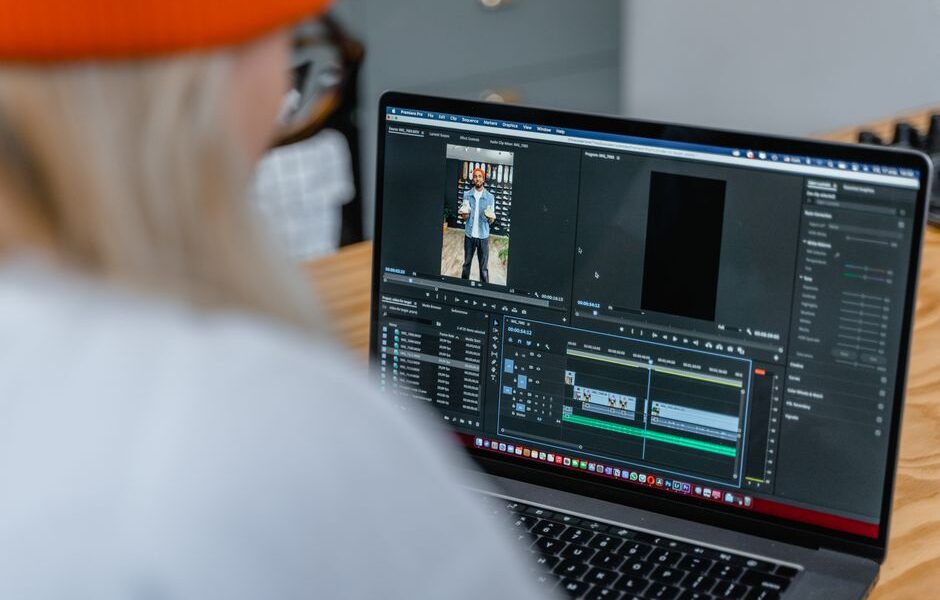 Osoba edytująca wideo w programie montażowym na ekranie laptopa