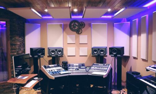 Studio nagraniowe z panelami akustycznymi na ścianach i suficie oraz sprzętem audio.